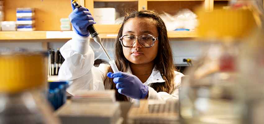 Black female researcher uses a pipette in the laboratory